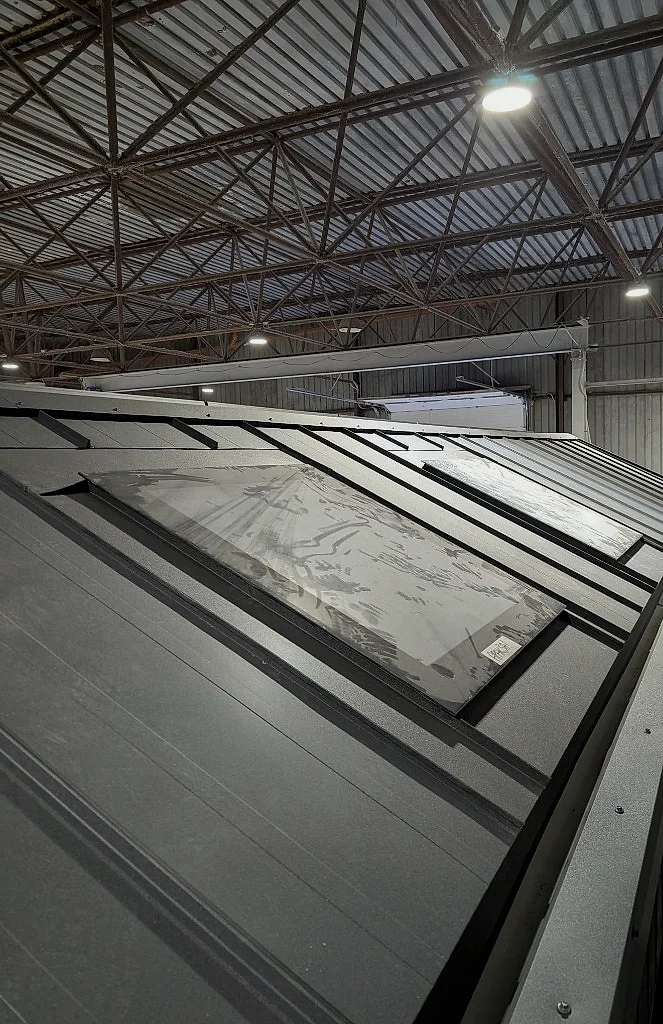 Standing-seam metal roof with stargazing skylight on the factory floor