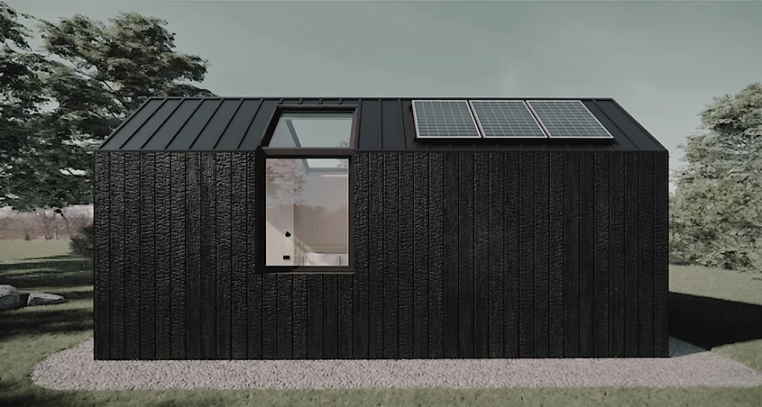 Side elevation render showing charred timber cladding, standing-seam roof and solar panels
